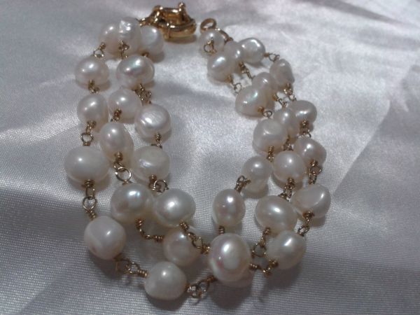 Pulseira dourada com perolas