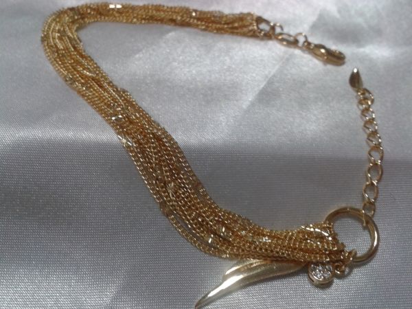 Pulseira com varias correntes e pingente de asa e strass